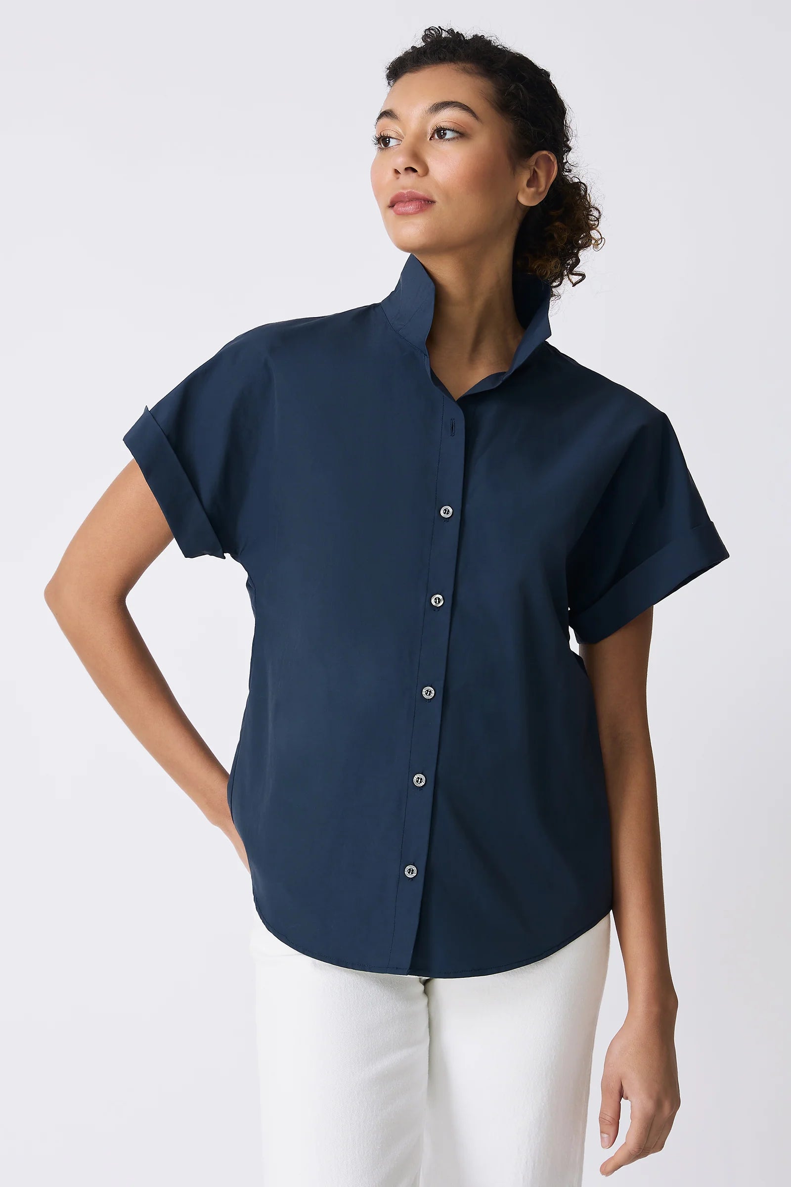 Woman wearing a navy blue short-sleeve shirt on a white background.