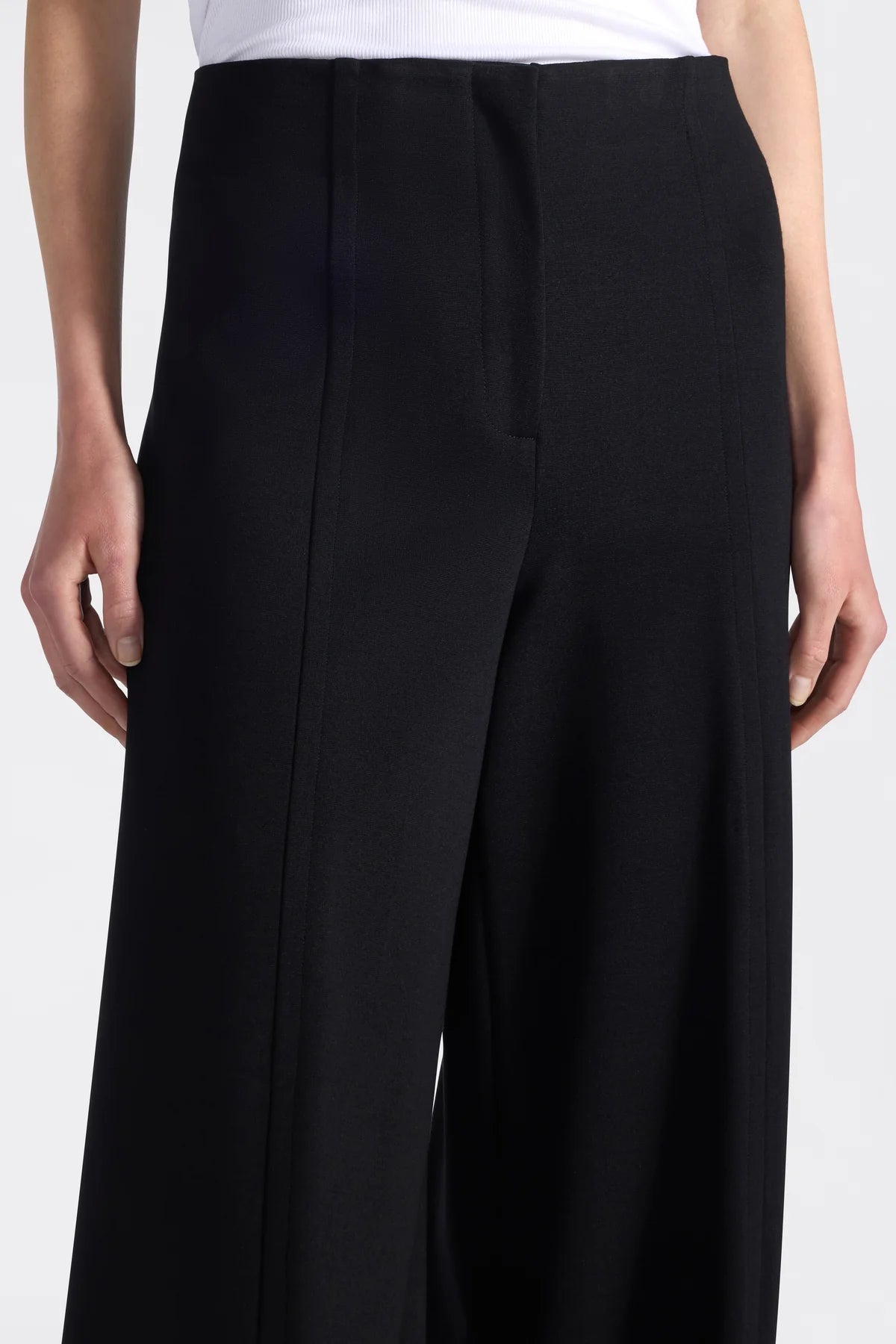 Black wide-leg pants worn by a person on a white background