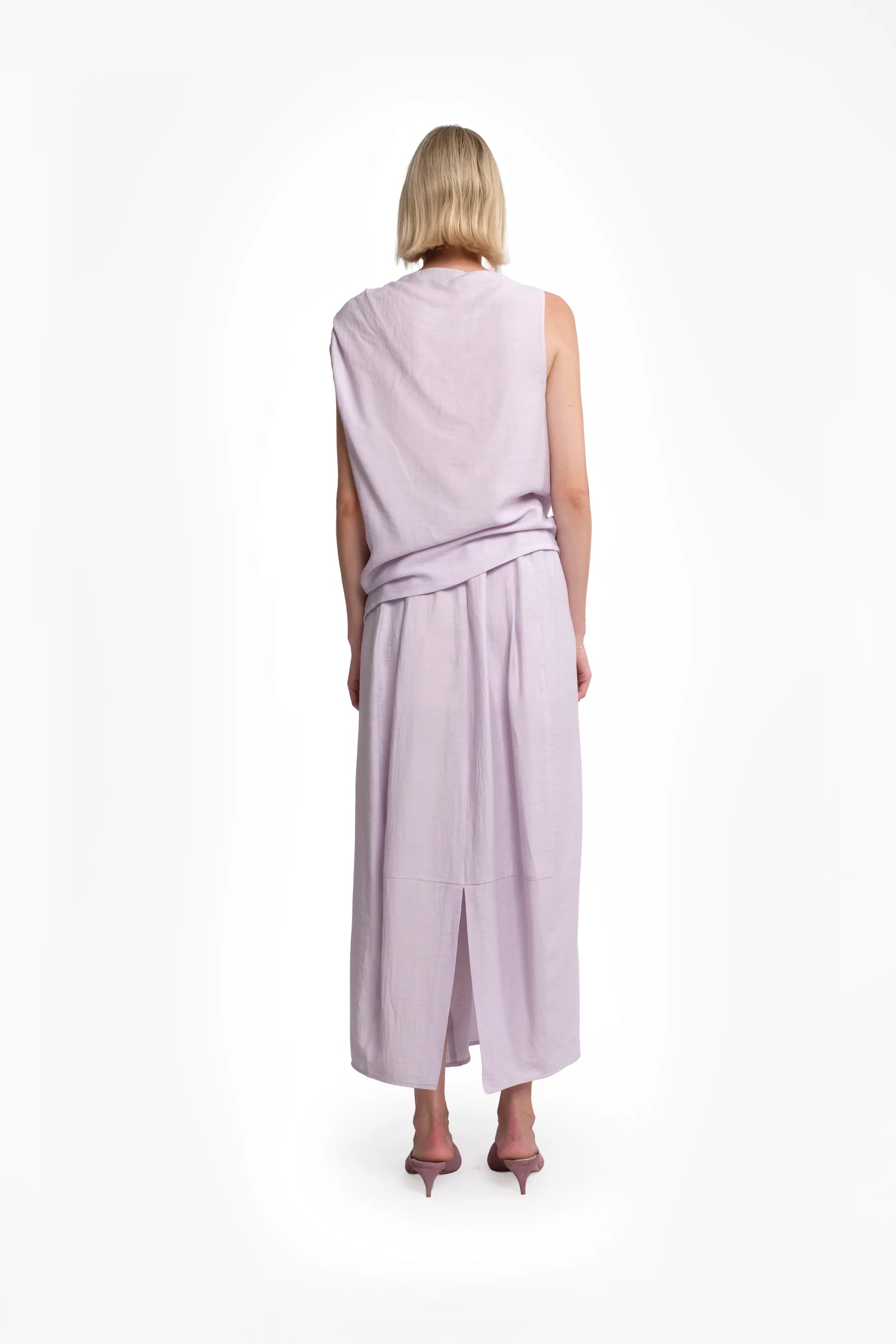 The back of a woman wearing a light purple sleeveless set on a white background.