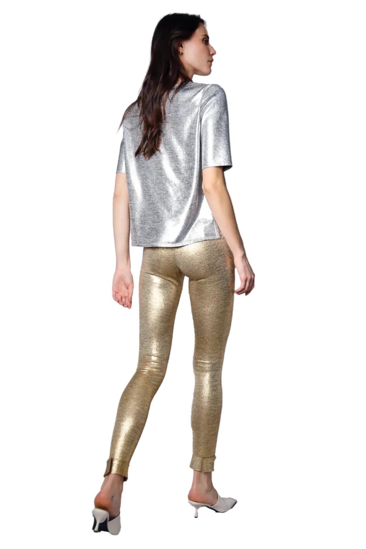 Woman wearing a silver top and gold leggings on a white background