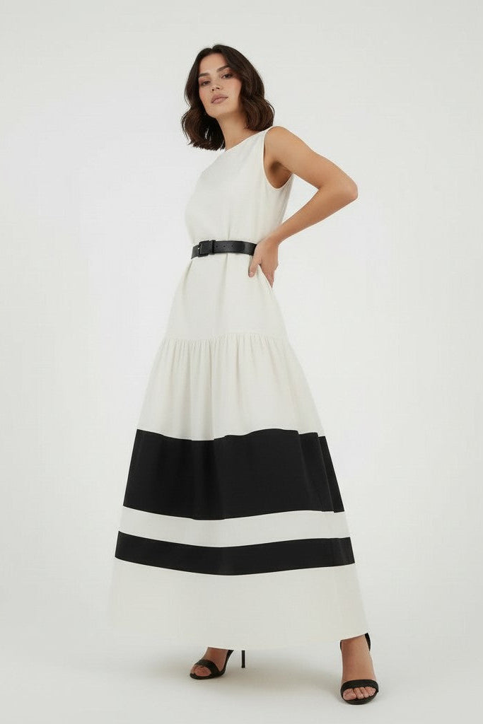 Woman wearing a off-white dress with black stripes on a plain background.