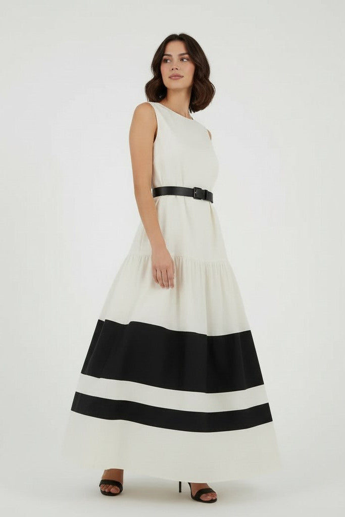 Woman wearing a off-white dress with black stripes on a plain background.