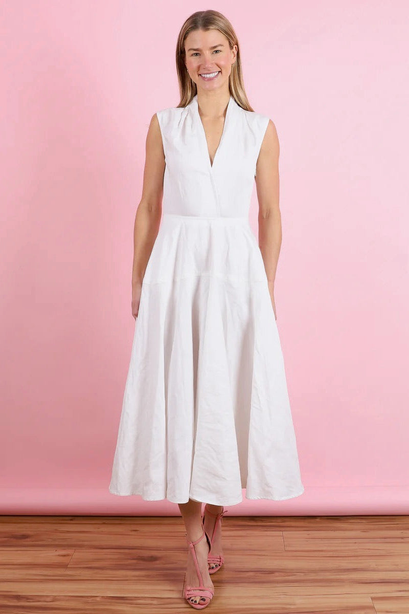 Woman wearing an off-white dress against a pink background.