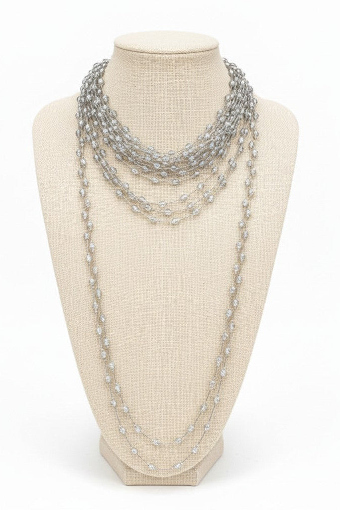 Multi-strand silver pearl necklace on a mannequin bust against a white background.