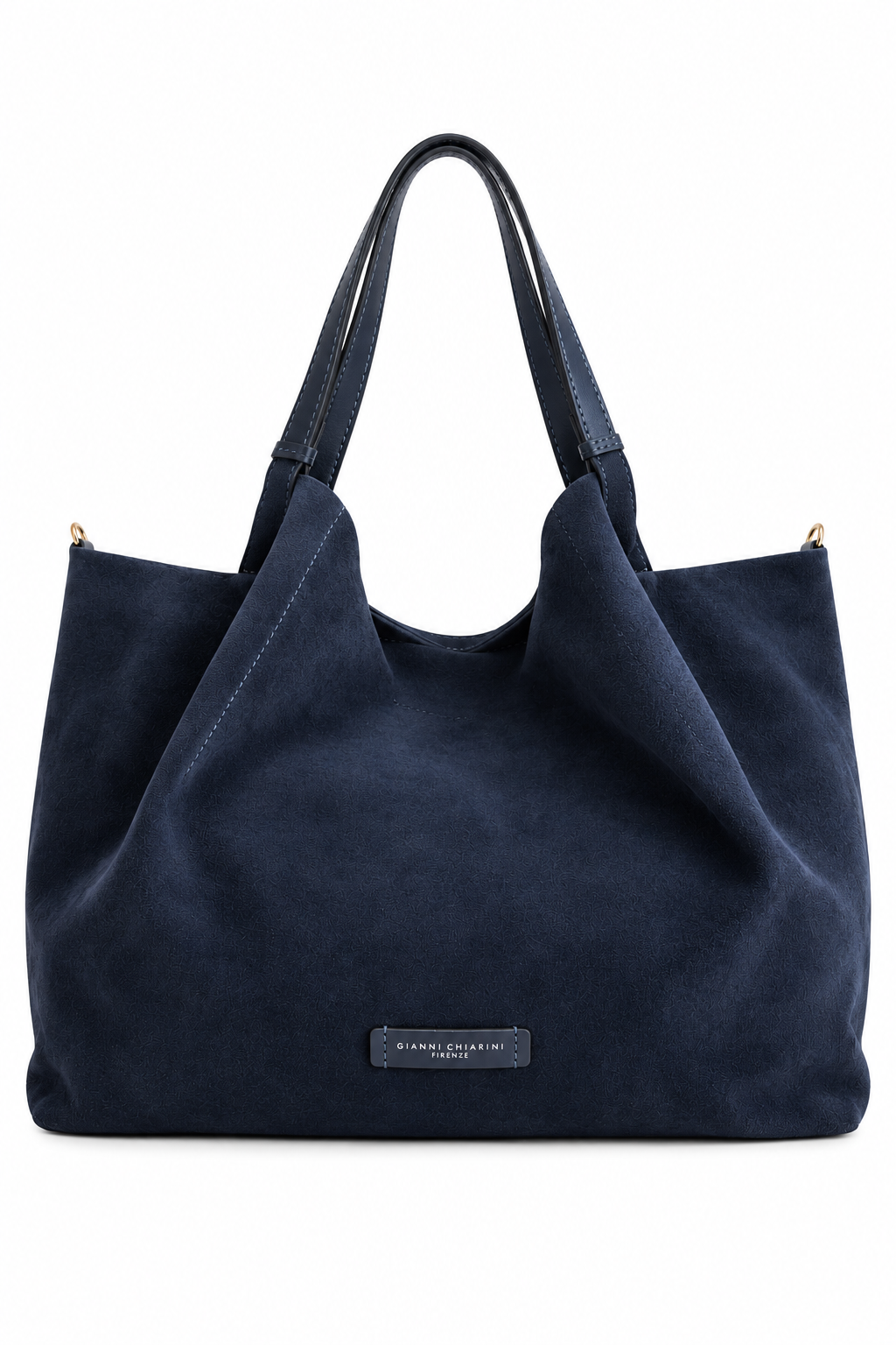 A navy blue suede slouchy tote bag with dual shoulder straps and a small black brand label on the front, photographed against a solid white background.