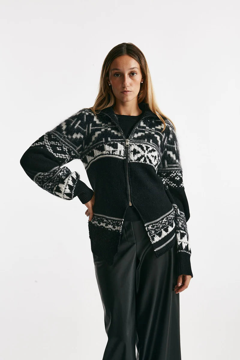 Woman wearing a black cardigan with white pattern on a white background.