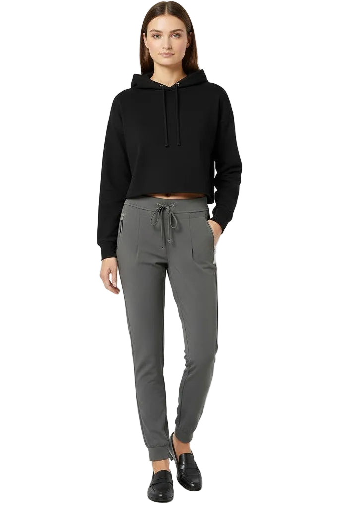 Woman wearing a black hoodie and gray jogger pants on a white background