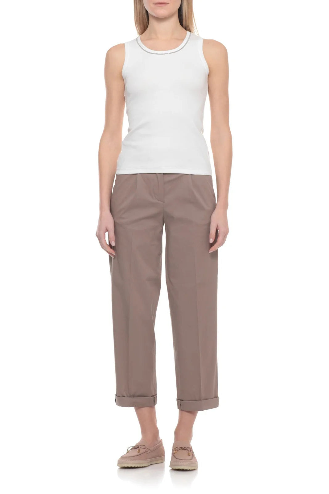 Woman wearing a white sleeveless top and brown pants on a white background.