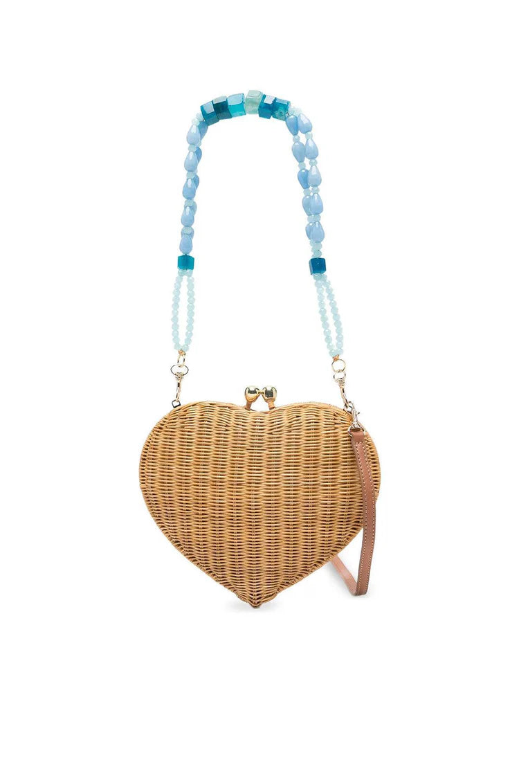 Heart-shaped wicker handbag with a beaded handle on a white background.