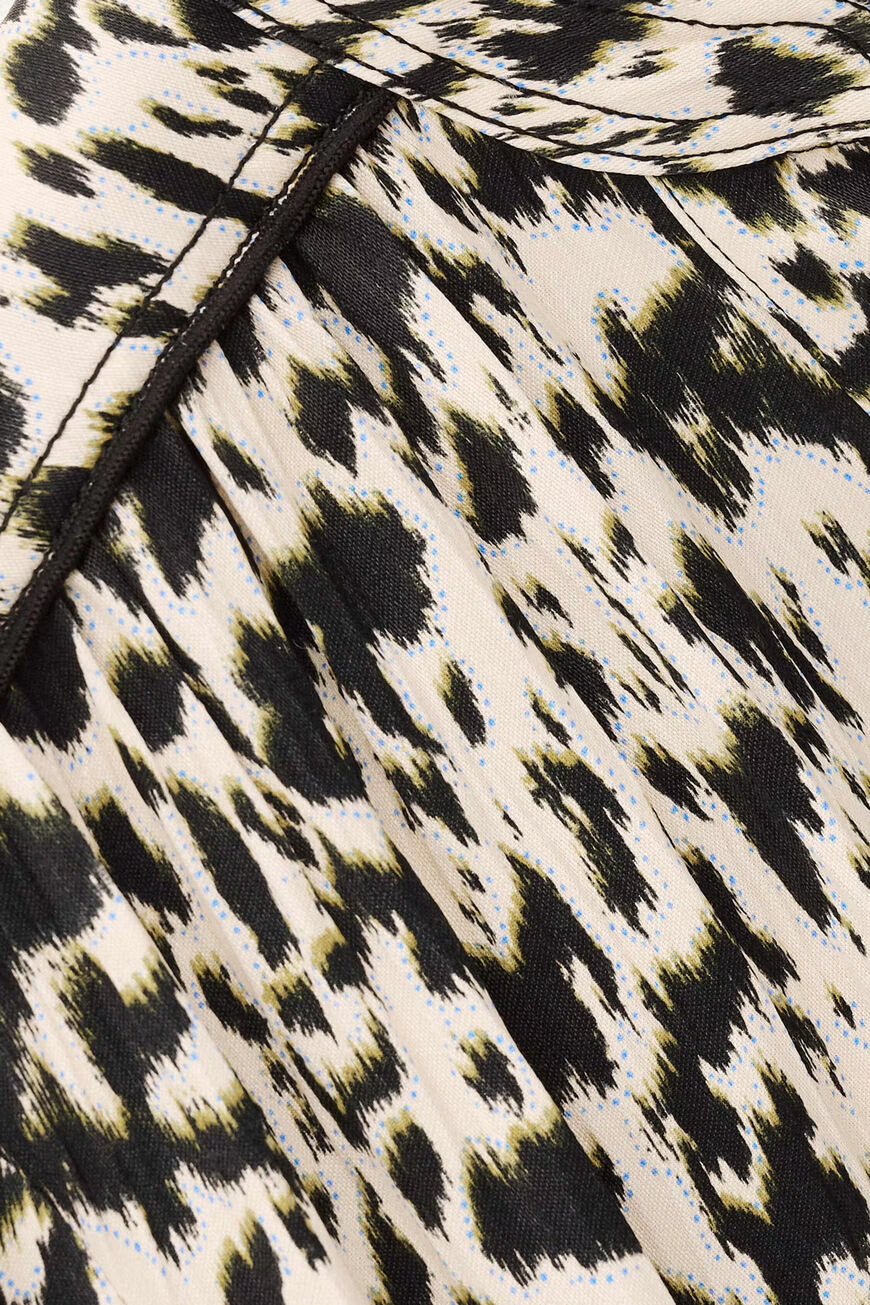 Close-up of a fabric with a black and white pattern on a beige background.
