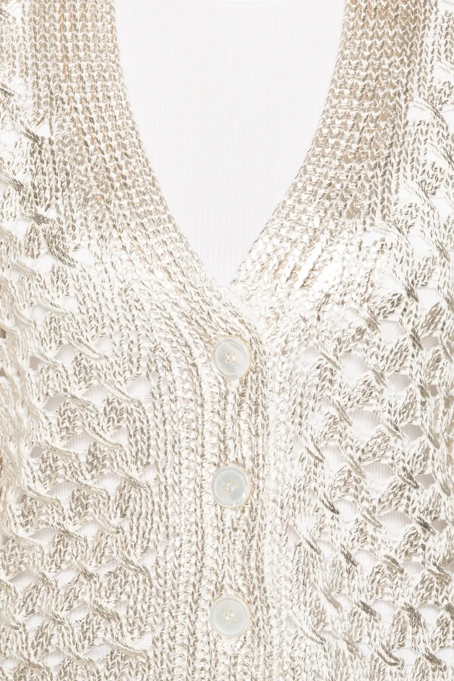 Close-up of a gold knitted cardigan with button details on a white background.