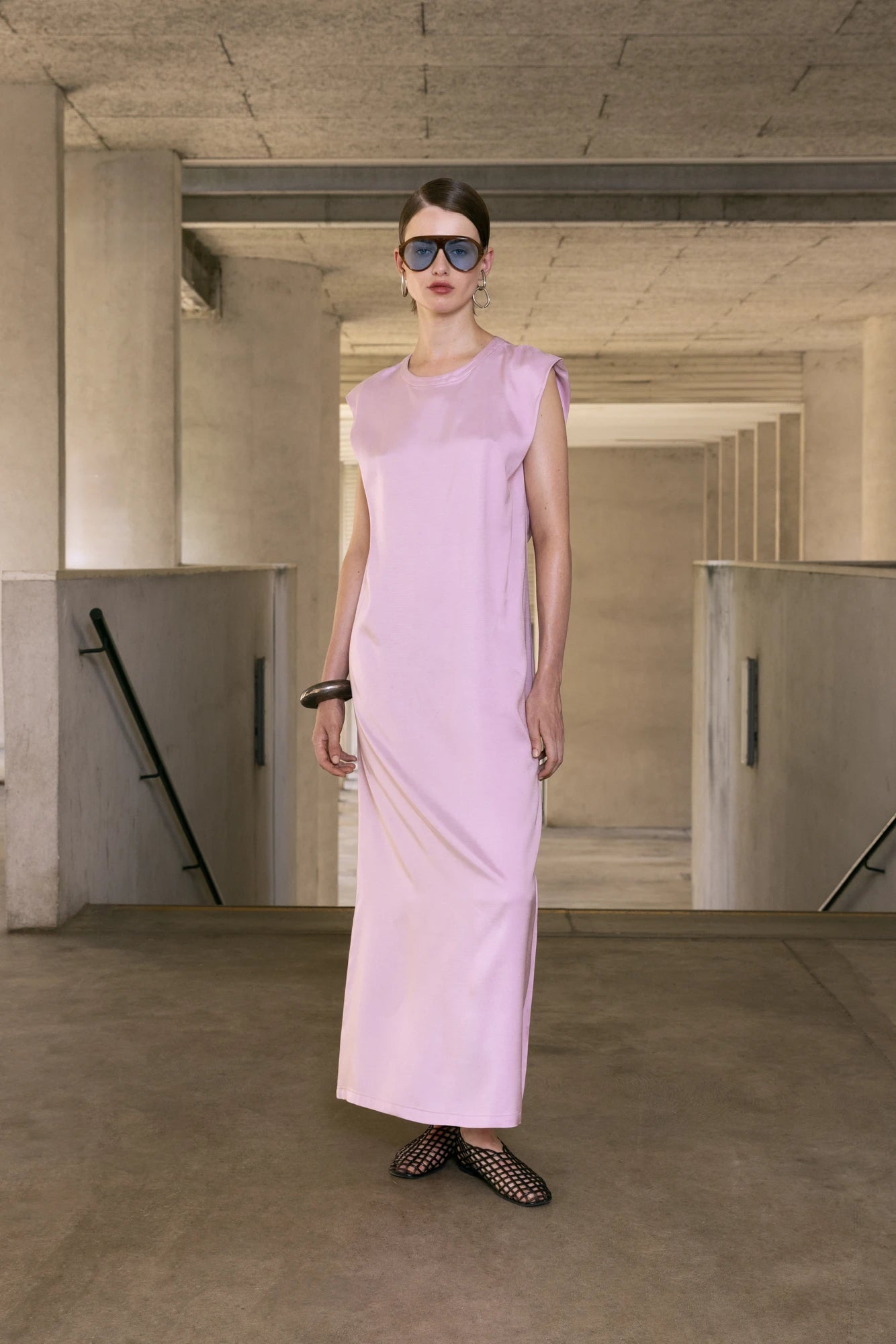 Woman wearing a light pink dress in an industrial setting