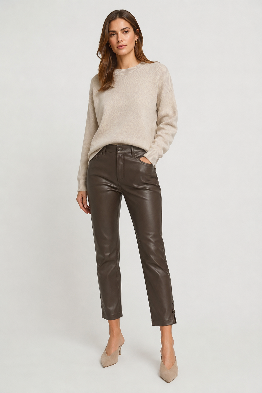 Model wearing dark brown Raffaello Rossi Ronija 7/8 vegan leather pants with a cream knit sweater and neutral heels, front view.