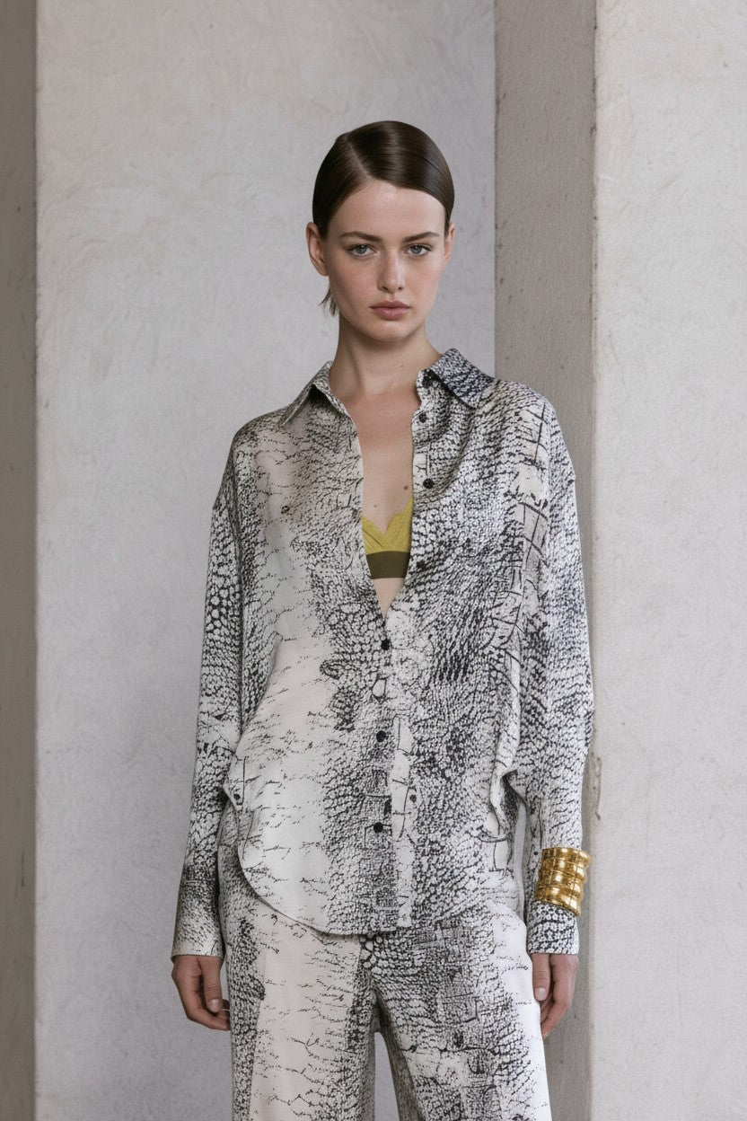 Close-up of a model wearing a patterned outfit against a neutral background.