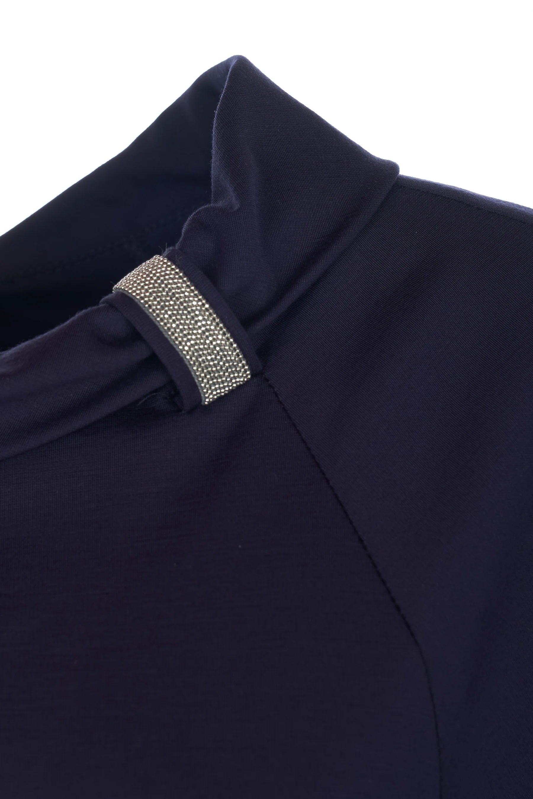 Close-up of a navy blue blouse with a decorative silver trim on a white background.
