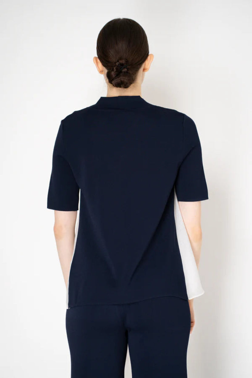 Person wearing a navy blue outfit with a white background.