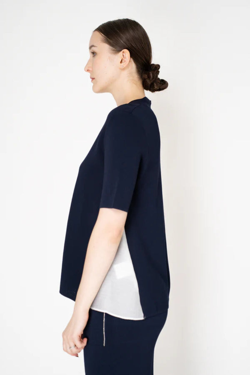 Woman wearing a navy blue outfit with a white background.