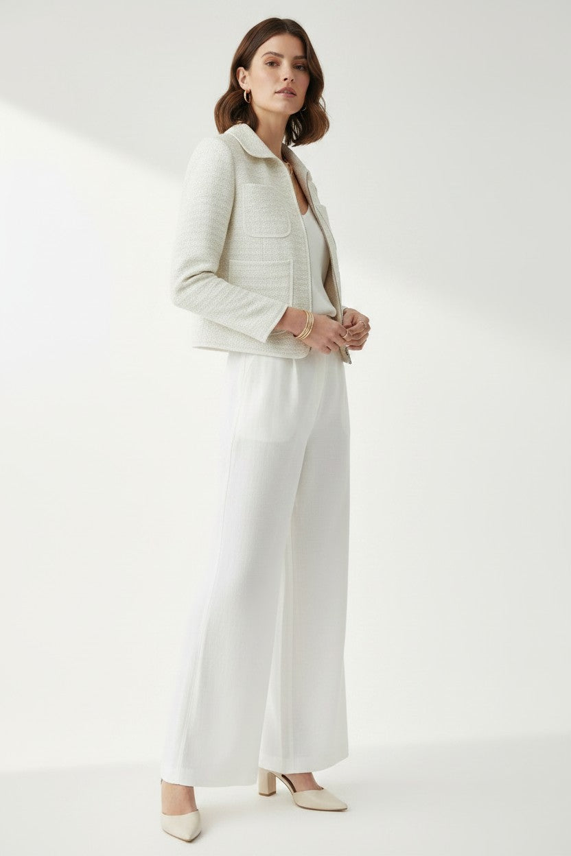 Woman wearing a white outfit on a plain background.