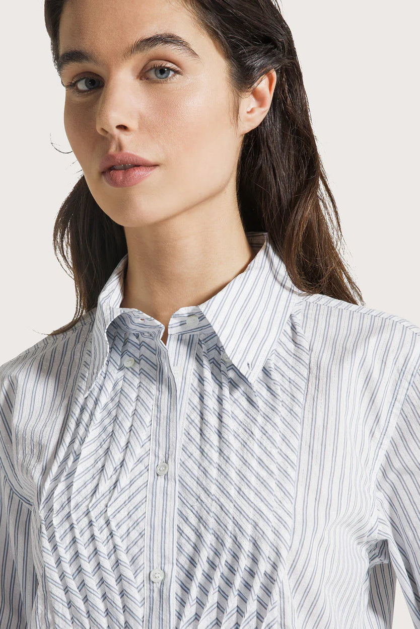 Close-up of a woman wearing a striped shirt against a plain background.