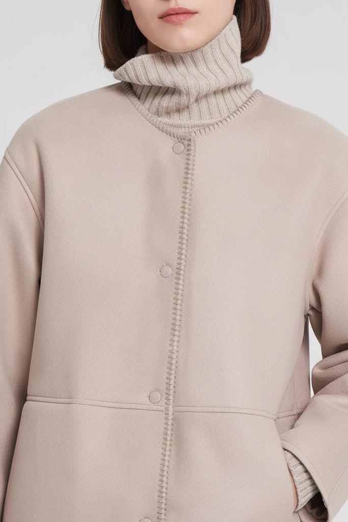 Beige coat with a textured collar on a plain background