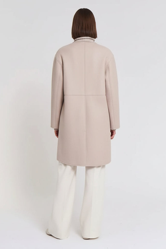 Person wearing a beige coat on a white background