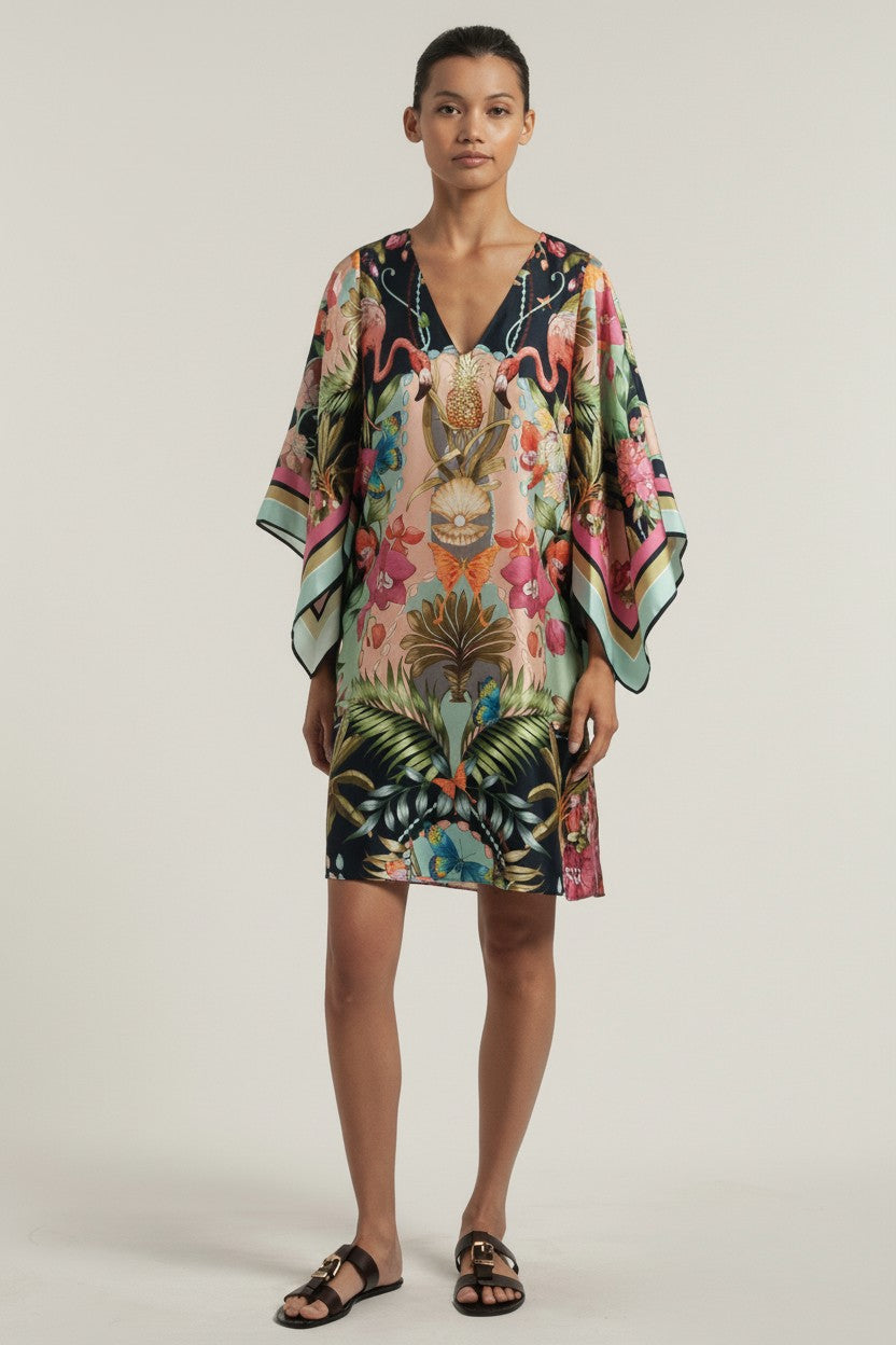 Woman wearing a colorful floral dress on a plain background.