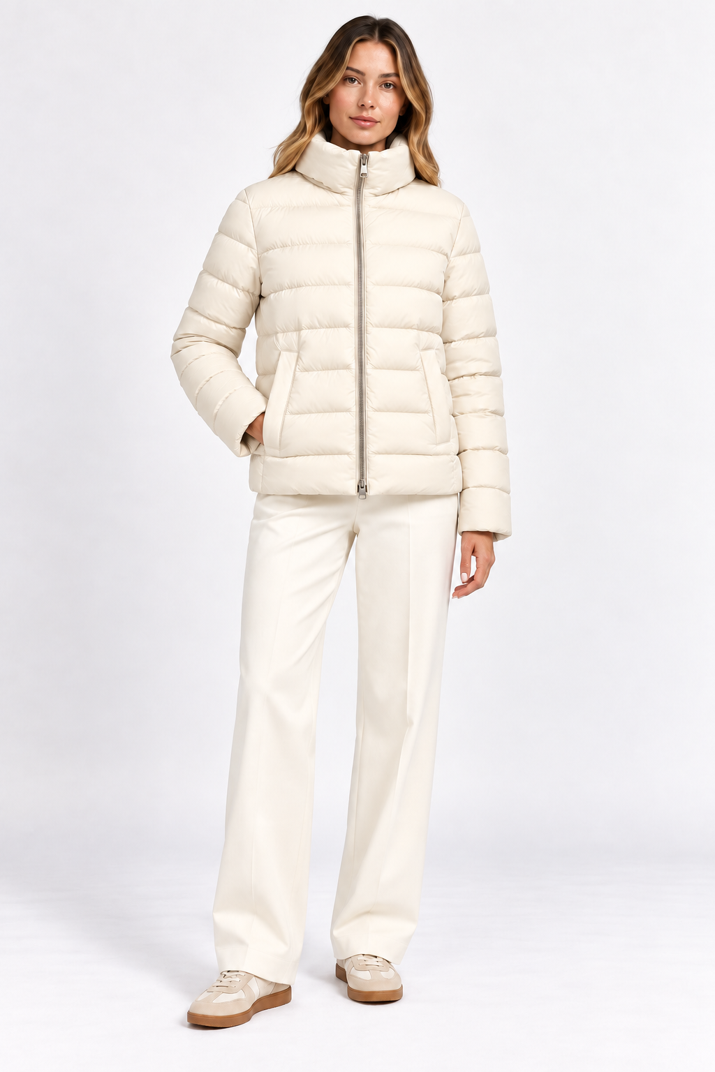 Model wearing cream quilted puffer jacket without the removable cape, front view.
