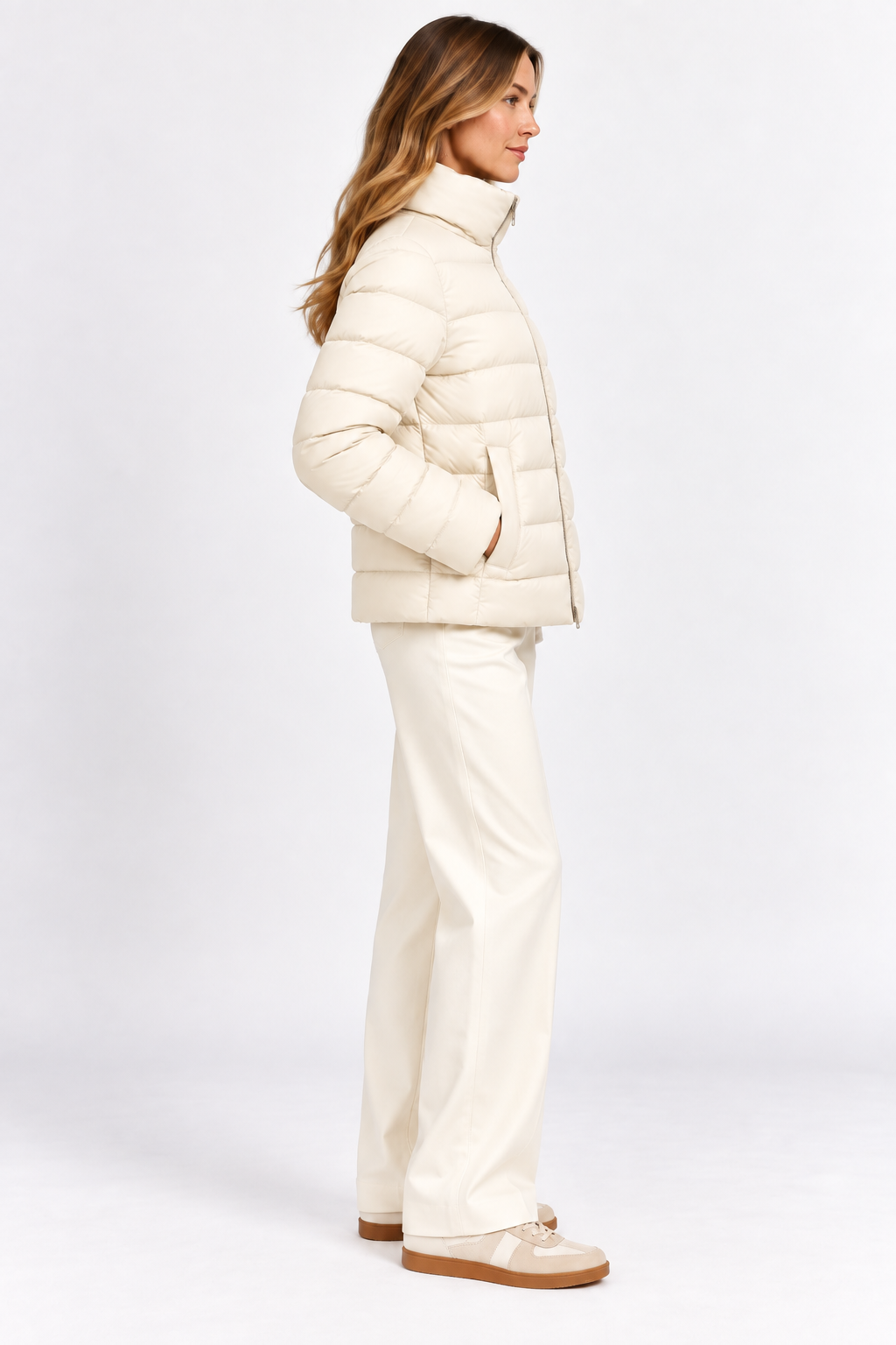 Model wearing cream quilted puffer jacket without the removable cape, side view.