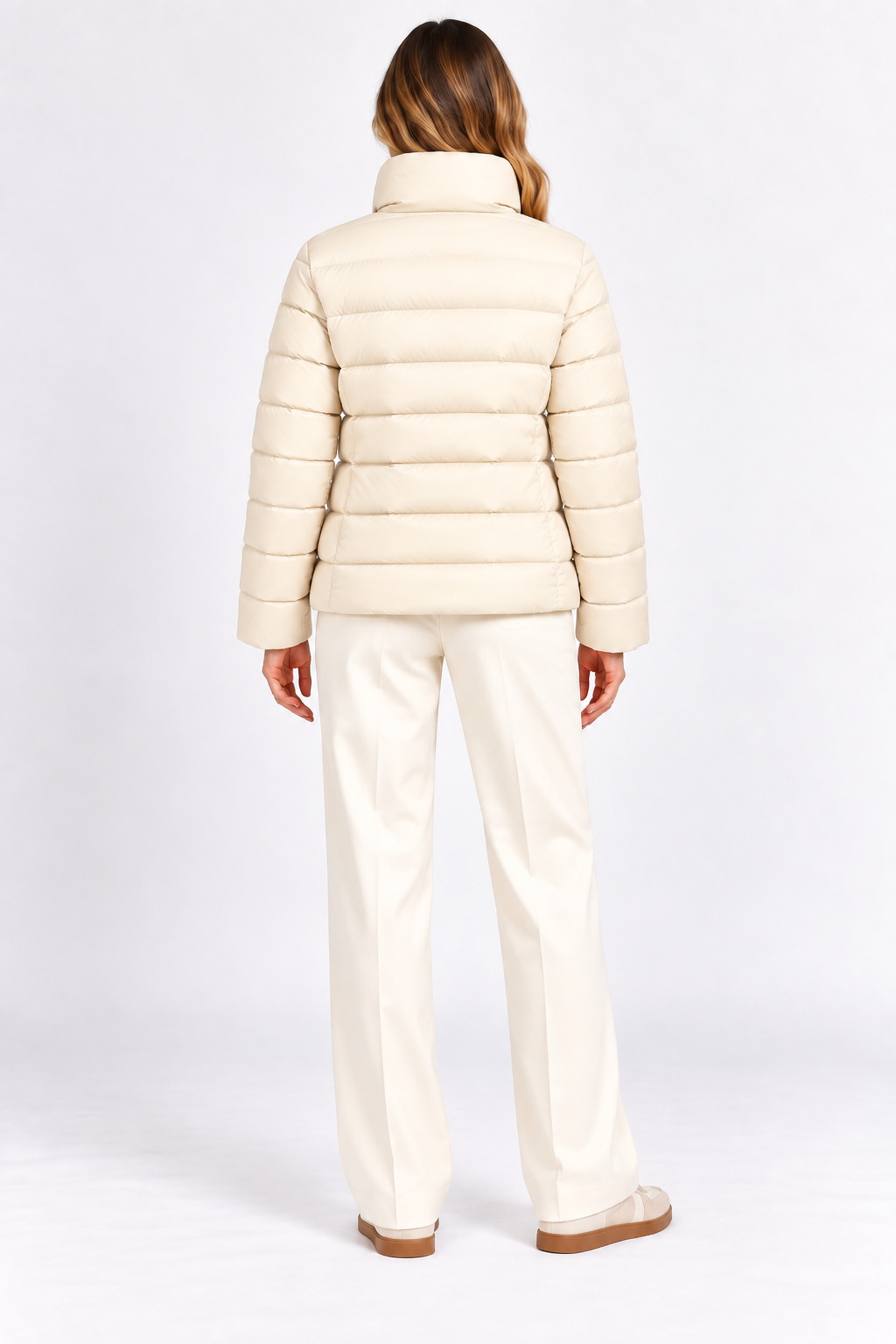 Model wearing cream quilted puffer jacket without the removable cape, back view.
