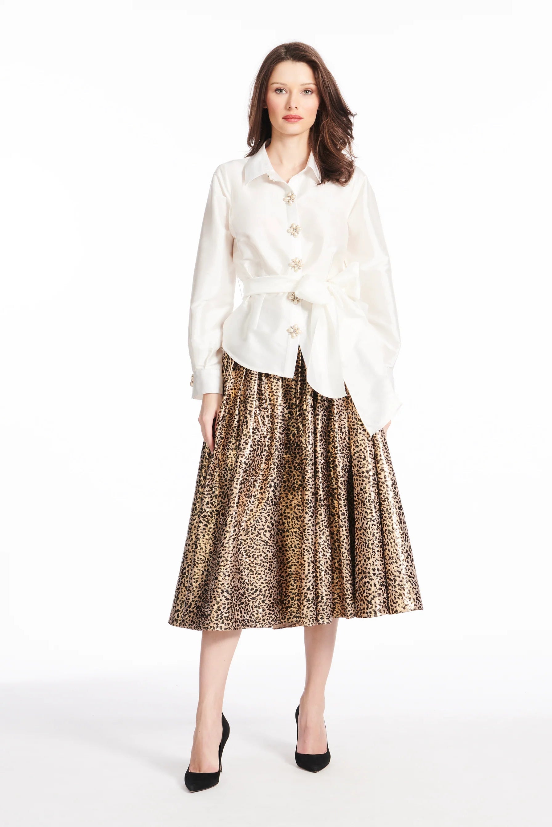 Woman wearing a white blouse and leopard print skirt on a white background.