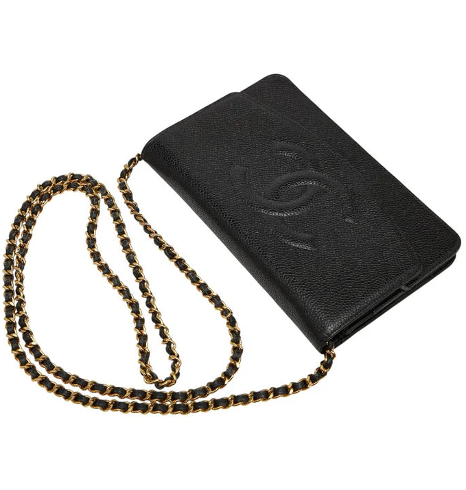 Black handbag with gold chain on a white background.
