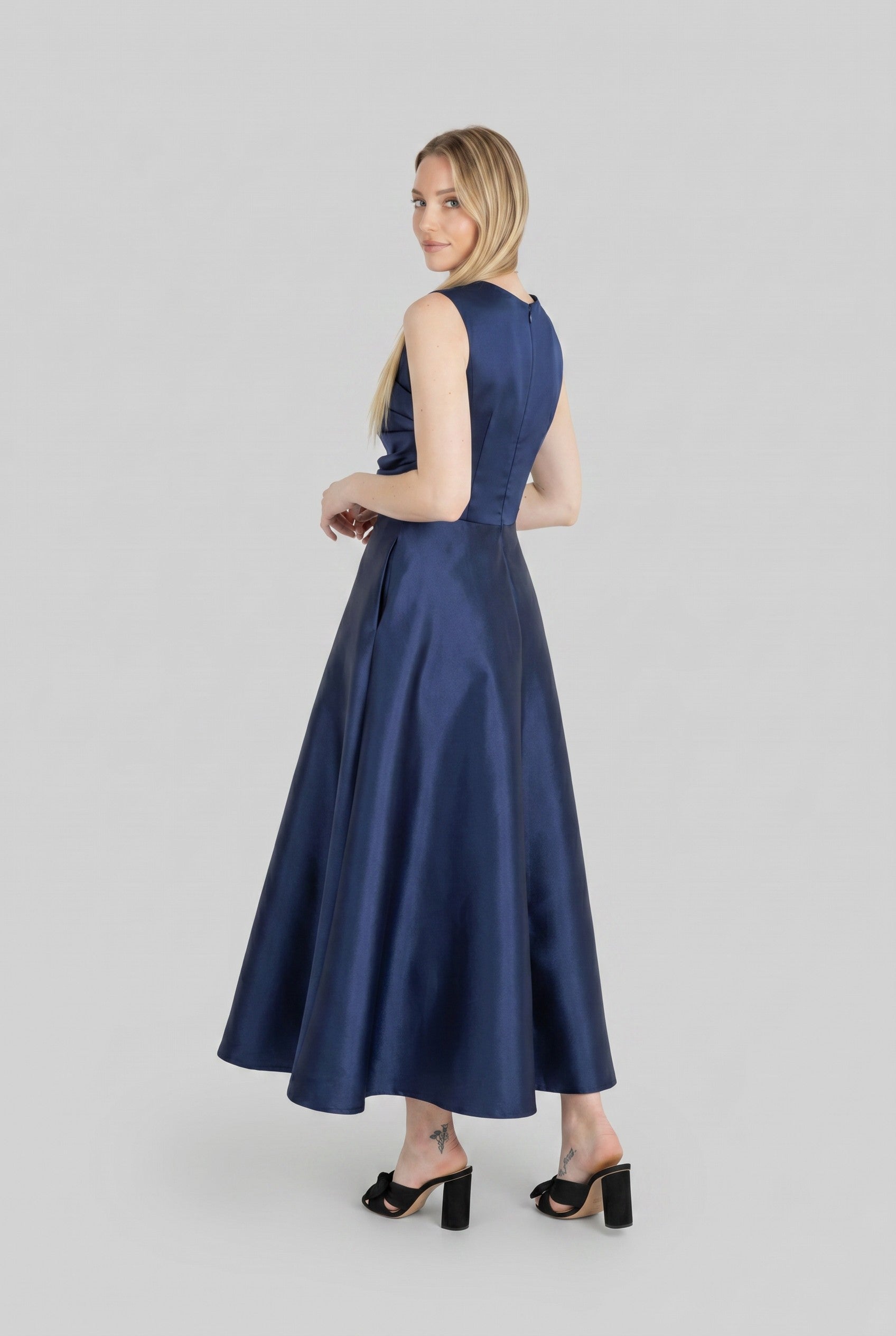 Woman wearing a blue dress on a light gray background.
