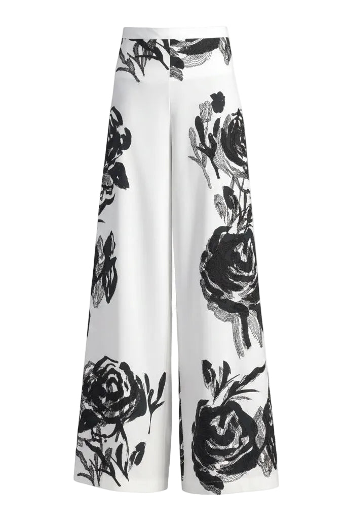 White pants with black floral embroidery on a white background.
