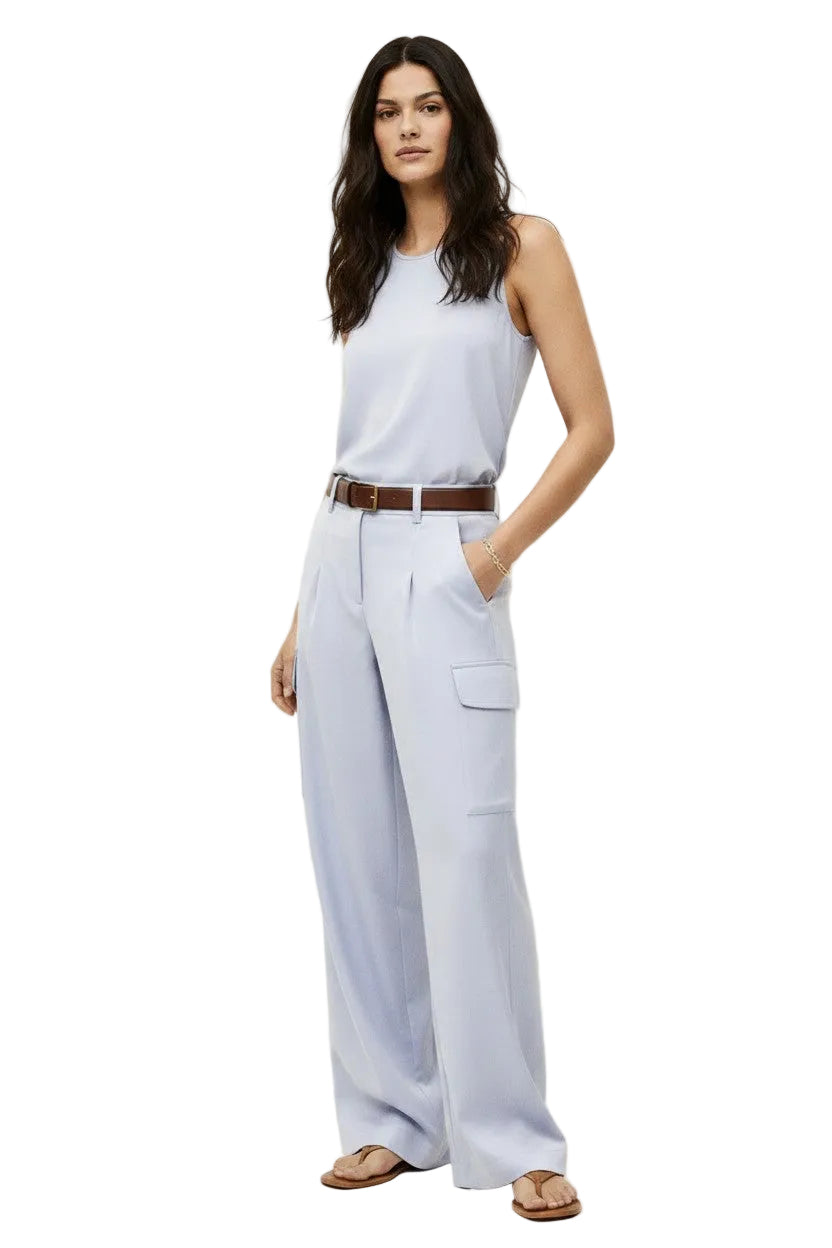 Woman wearing a lavender sleeveless top and wide-leg pants on a white background.