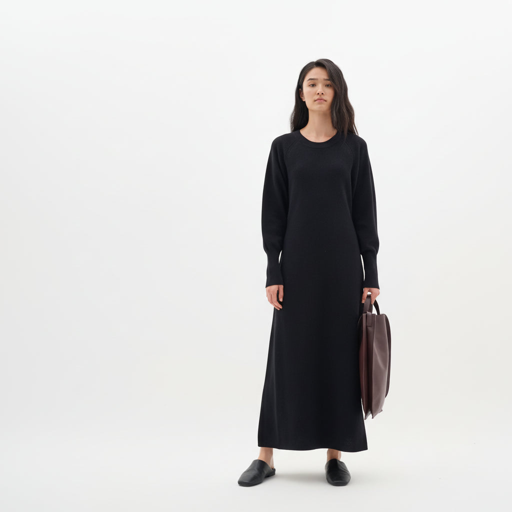 Woman wearing a black dress holding a brown bag on a white background